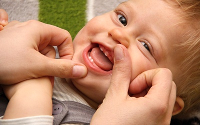 A baby whose two top teeth and two bottom teeth have erupted
