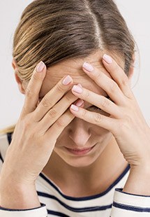 Frustrated woman with head in hands