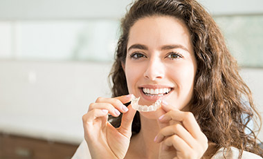 Woman placing Invisalign tray
