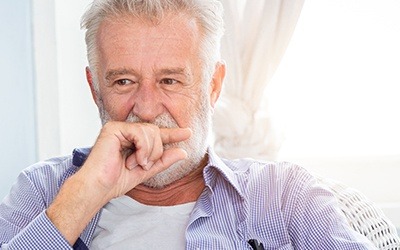 Older man covering his mouth