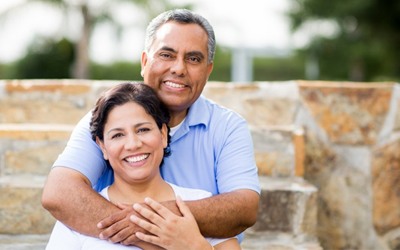 An older couple smiling and hugging.