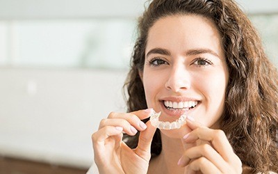 Woman placing Invisalign tray