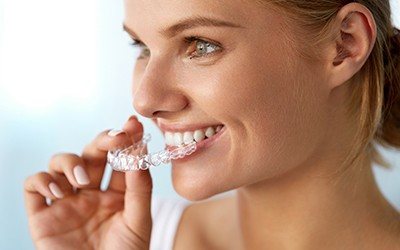 Woman holding Invisalign tray