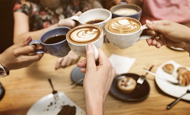 women toasting cups of coffee