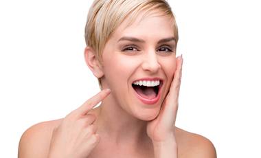 woman blonde hair pointing at teeth