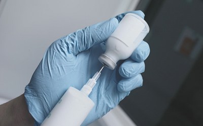 A syringe being used to pull medication from a bottle