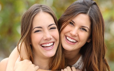 Two young women smiling and hugging