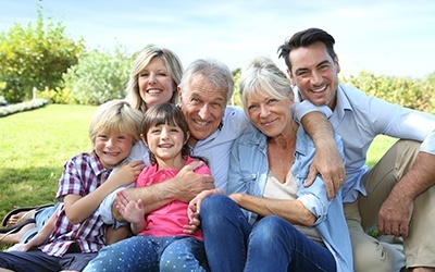 Three generations of family smiling together outdoors