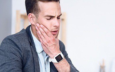 Man in pain holding jaw