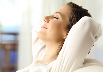 Relaxed woman with hands behind head